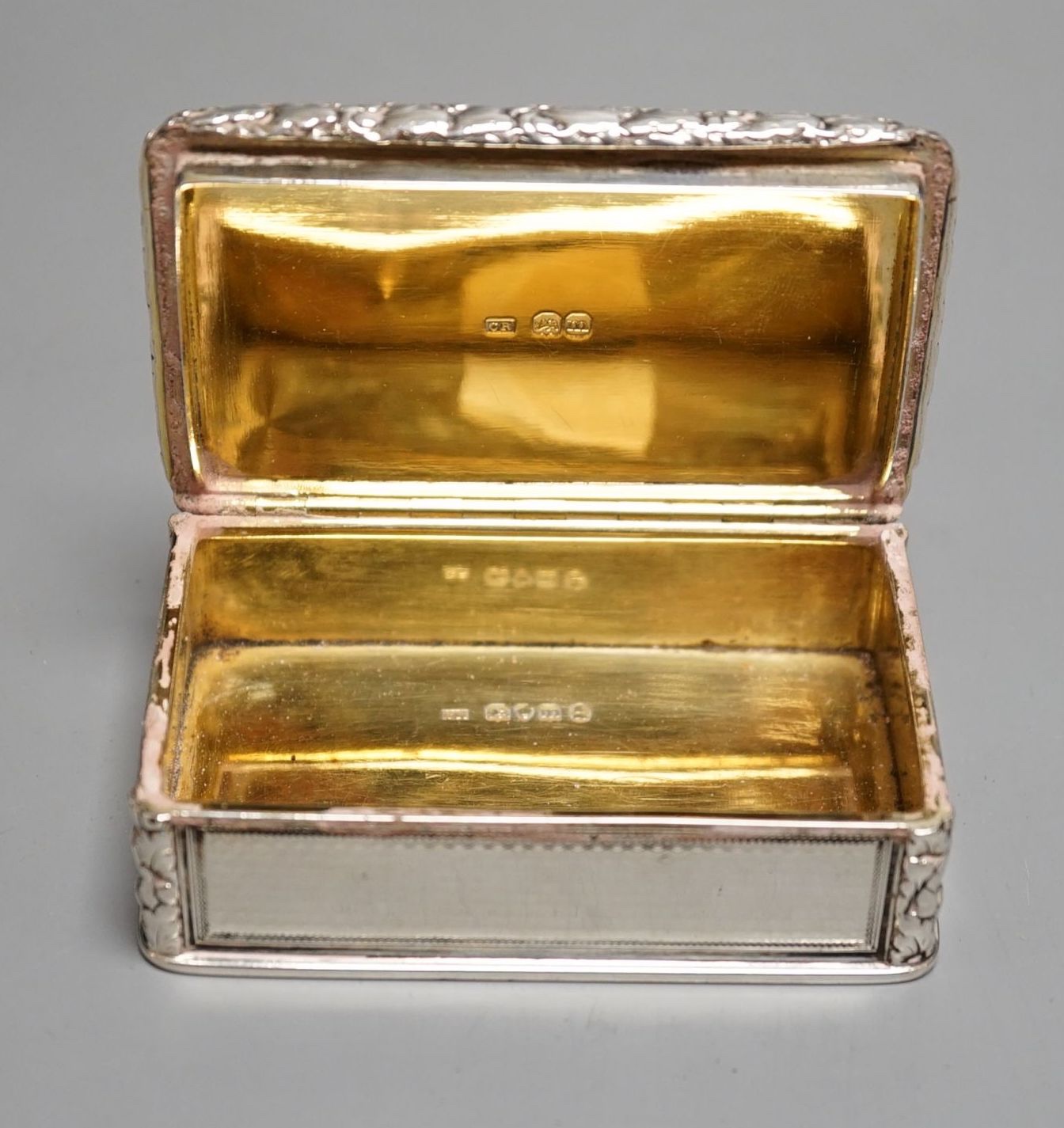 A George IV engine turned silver rectangular snuff box, with yellow metal applique, Charles Rawlings, London, 1827, 82mm.